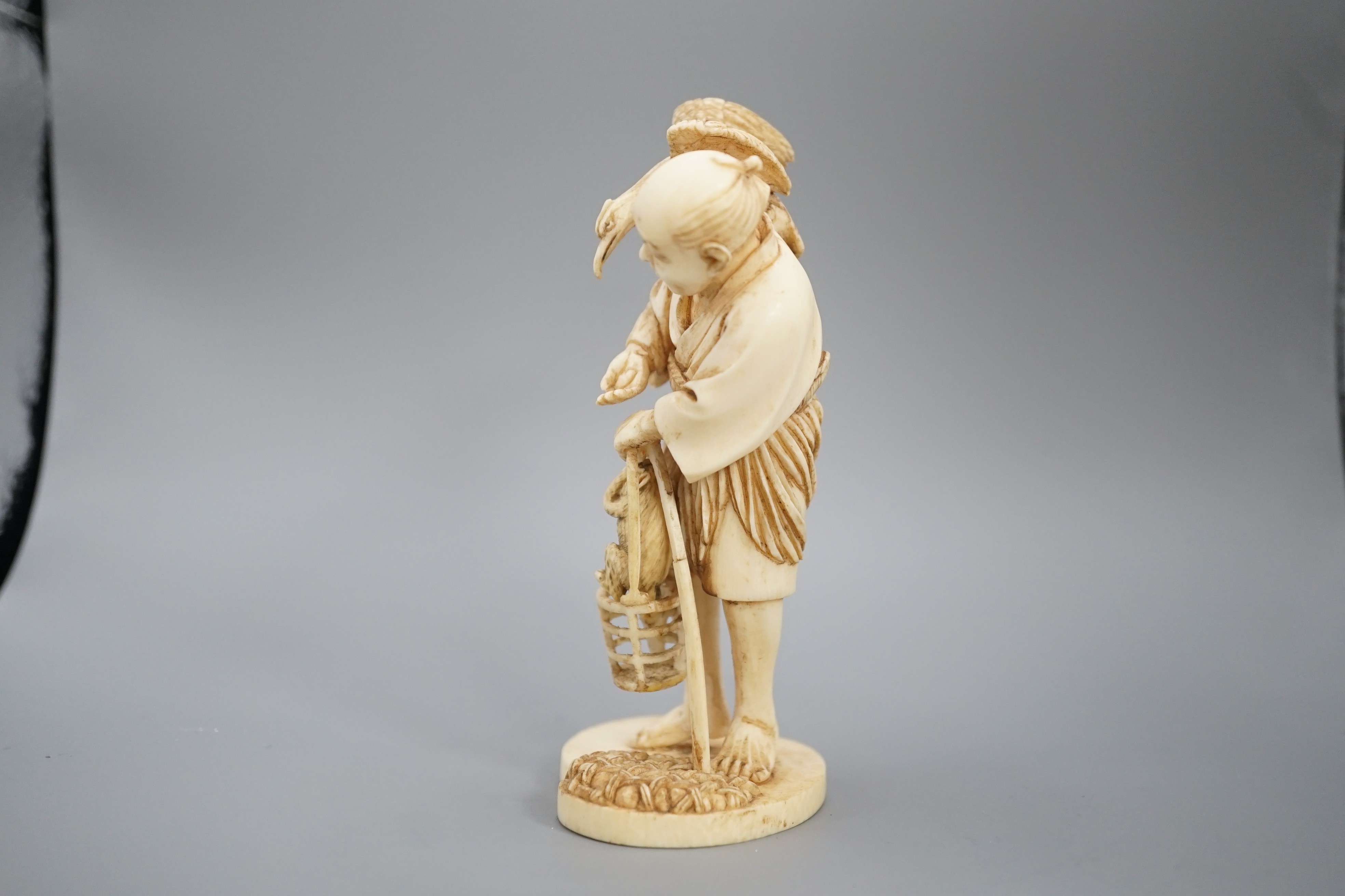 A Japanese ivory okimono of a cormorant fisherman, signed, Meiji period, 11cm and a small carving of a monkey
